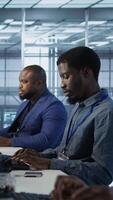 Vertical System administrators in data center implementing AI predictive maintenance systems. Teamworking server hub specialists using artificial intelligence to identify hardware failures, camera A video