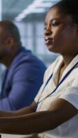 Vertical Data center engineer wearing headphones enjoying songs, maintaining company network infrastructure. Woman in server hub listening music while ensuring optimal system performance, camera A video