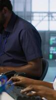 Vertical IT specialists in data center doing brainstorming, maintaining company network infrastructure. Team of server hub computer scientists chatting, ensuring optimal system performance, camera A video