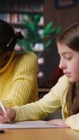 Vertical Diverse scholars helping each other finish the homework at the library, staying after classes to solve their school assignment. Clever diligent girls working hard for a scholarship. Camera B. video