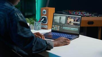 editor analyzing film montage on laptop screen before editing color grading and lighting in creative office. Post production studio employee working with raw footage on notebook, camera A video