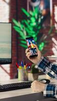Man in home office looking at social media feed with live broadcasts from online content creators. Employee at work using social network application with livestreams done by influencers, camera B video