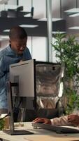 Vertical Businesswoman engages with delivery employee highlighting food delivery services in a modern office. Black female manager serving her lunch and catching up on work tasks, efficiency. Camera B. video