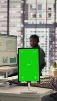Vertical Female manager seated at workstation with green screen on devices, working on solving administrative tasks for enterprise growth. Developing performance metrics to support firm goals. Camera B. video