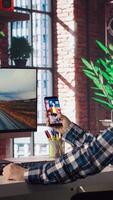 Man at home watching social media live broadcasts, interacting in chat with online content creators. Person holding phone, using social network app to partake in livestreams, camera A video