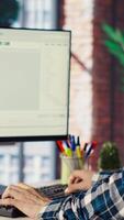 Software engineer at computer coding, creating software using isolated screen tablet. IT specialist in home office working with code editor, building applications using PC and mockup device, camera B video