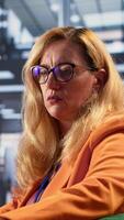 Vertical Diverse businesswomen trying to discuss with disconnected detached CEO, suffering from depersonalization and apathy because of burnout. Gender equality women in business concept. Camera A. video