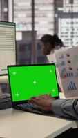 Vertical African American businessman at office with mockup screen analyzing financial data and developing growth strategies to achieve company success. Male staff member managing important tasks. Camera B. video