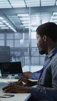 Vertical Cheerful coworkers in data center implementing AI predictive maintenance systems. Server room engineers using artificial intelligence to identify hardware failures impacting operations, camera A video