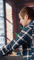 Man listening music while using AI program turning text prompt into videos. Person putting on headphones, interacting with text to artificial intelligence generative model, camera B video