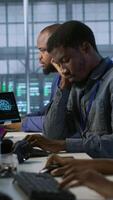Vertical Tired data center engineer yawning, suffering from lack of sleep while maintaining company network infrastructure. Bored server hub worker feeling fatigued, struggling to stay awake, camera A video