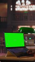 Vertical Black librarian typing on laptop with chroma key in a quiet public library, dedicated to organizing study resources and mentoring students in their academic journey with pride. Camera A. video