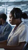 Vertical Portrait of smiling engineer hearing podcasts to make time pass faster while working in server farm to optimize it for data processing requirements. Happy woman listens songs in data center, camera A video