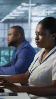 Vertical Software developers in data center implementing AI predictive maintenance systems. Focus on man in server hub office using artificial intelligence to identify hardware failures, camera A video