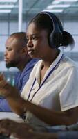 Vertical Engineer arrives in data center, puts headphones on, implementing AI systems. Server farm expert sitting down at desk, listening music and using artificial intelligence to prevent failures, camera A video
