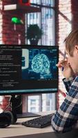 Admin uses computer for artificial intelligence computing simulation, waiting for code to finish compiling. Man works with AI deep neural networks, rubbing forehead with pen, feeling bored, camera A video