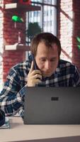 Manager in home office sitting at desk in front of laptop, calling employee to confront him about mistakes. Supervisor using notebook to do job online, doing telephone call to scold worker, camera A video