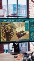 Architectural designer in home office moving assets in 3D modeling program, doing interior design project. Man looking at CAD software interface on PC, making home floor plans, camera A video