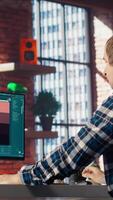Man in apartment workspace using AI software turning text prompt into photos. Person in brick wall home uses text to image artificial intelligence generative models on computer, camera B video