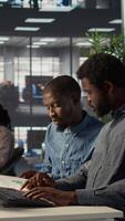 Vertical Black corporate team collaborate on global investment strategy, employing their extensive business expertise to work on data driven decisions. Solving administrative tasks for efficiency. Camera B. video