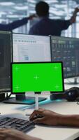 Vertical IT experts using green screen tablet, working together in server farm to optimize it for data processing requirements. Close up of coworkers coding on chroma key device in data center, camera A video