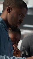 Vertical African American team collaborates on a financial planning project in a business space, emphasizing teamwork and data analysis to make informed decisions for future firm growth. Camera A. video