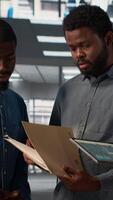 Vertical Professional team analyzing archived data on a financial file during meeting, collaborating on enterprise solutions and solving tasks to improve performance for long term growth. Camera A. video