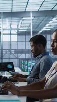Vertical Data center engineers maintaining company network infrastructure by installing, configuring, troubleshooting and repairing hardware. Server hub workers ensuring optimal system performance, camera A video