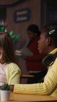 Vertical Elementary school pupils working with a professor solving exercises for the class homework, developing learning skills at a study desk. Tutor explains the curriculum materials to girls. Camera B. video
