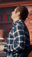 AI engineer in home office stretching back while looking at PC screen, feeling fatigued while executing code. Artificial intelligence developer feeling backpain, relieving pain, testing code, camera B video