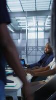 Vertical Technician entering data center, tuning music on and starting work on AI predictive maintenance systems. Server hub staff member using artificial intelligence to identify hardware failures, camera A video
