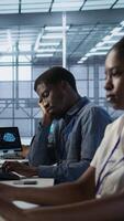 Vertical Tired data center engineer yawning, suffering from lack of sleep while maintaining company network infrastructure. Bored server hub worker feeling fatigued, struggling to stay awake, camera A video
