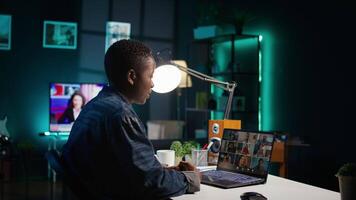Remote worker greeting colleagues during business meeting on videocall in apartment office. Self employed woman participating in remote videoconference telework call while at home, camera B video