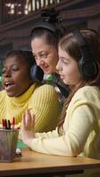 Vertical Young students and tutor attending an online class via call in the library, focused on distance learning and completing a school assignment with other classmates on the network. Camera A. video