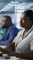 Vertical Focus on server hub employee developing disaster recovery plans ensuring minimal downtime. African american man in data center using data analytics to monitor performance, camera A video