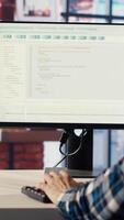 Man in home office looks at green screen tablet and computer, typing and executing programming code. Coding application used by IT developer writing and testing code using chroma key device, camera B video