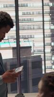 Vertical Black analyst working with monthly revenue balance to create financial plans using online tools, analyzing data infographics. Businessman managing organizational goals for efficiency. Camera A. video
