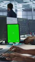 Vertical Programmers use isolated screen tablet in server room, developing disaster recovery plans ensuring minimal downtime. Data center employee looking at chroma key device, monitoring performance, camera A video