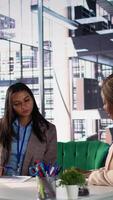 Vertical Diverse team of women collaborate in a problem solving meeting, promoting gender equality and social development in business industry. Managers demonstrating teamwork and progression. Camera B. video