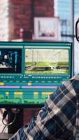 editor wearing headphones doing montage, using specialized software application, zoom in shot. Freelancer using editing tools on PC to cut movie project footage, camera A closeup video