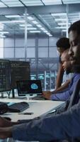 Vertical Engineer arriving in data center, saluting colleagues, starting maintaining company network infrastructure. Woman entering server hub, starting job shift, ensuring optimal system performance, camera A video