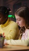 Vertical Preteen girls focus on reading the required books at a study desk, developing their academic skills and literary language at the library. Scholars enjoy lecture for the school curriculum. Camera B. video