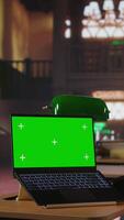 Vertical Focused schoolgirl engaged in academic tasks with green screen at a library, working on school assignments with her laptop. Solving class work tasks, searches information on internet. Camera A. video