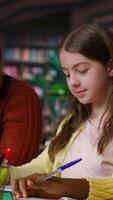 Vertical Female teacher assisting pupils with class homework and mentoring, providing academic instruction and support to help pass school assignments. Tutor lecturer gives private lessons. Camera B. video