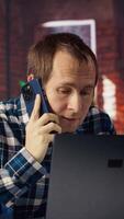 Manager in home office sitting at desk in front of laptop, calling employee to confront him about mistakes. Supervisor using notebook to do job online, doing telephone call to scold worker, camera B video