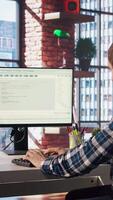 Man in home office looks at green screen tablet and computer, typing and executing programming code. Coding application used by IT developer writing and testing code using chroma key device, camera A video