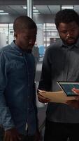 Vertical Black leader reviews company strategy with her team members in a modern corporate office, making key business decisions to support organizational growth. Discuss resource allocation. Camera A. video