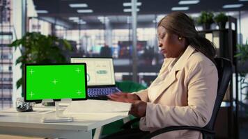 African american empowered woman working with isolated chroma key on tablet, working on planning data analytics or income at her desk. Developing a strategy to increase funds for project. Camera B. video