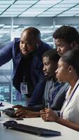 Vertical Coworkers in data center doing brainstorming, implementing AI predictive maintenance systems. Server hub colleagues discussing, using artificial intelligence to identify hardware failures, camera A video