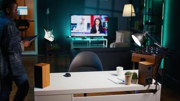 Freelancer in neon lit home office sitting at desk and typing on laptop keyboard. Remote employee using electronic device to do customers relations job online, answering inquiries, camera B video